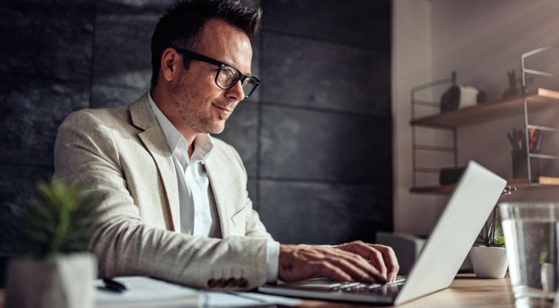Une personne en habit qui tape sur un clavier d’ordinateur.