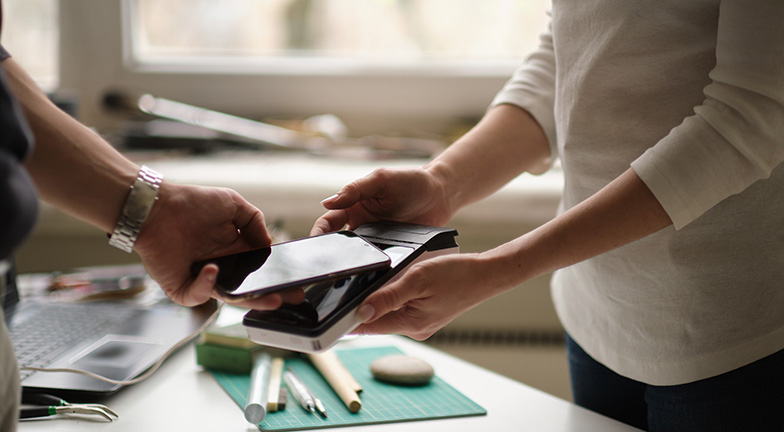 Une personne utilisant un numéro de carte de crédit temporaire ou une carte de crédit à usage unique sur son téléphone mobile.