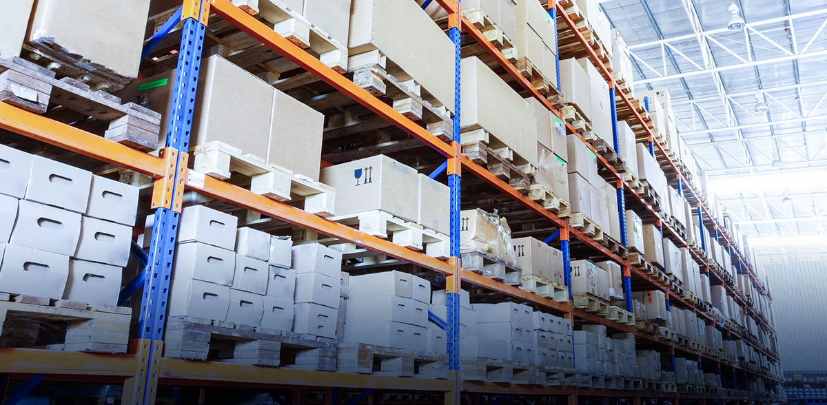 Rangées d’étagères industrielles avec des tas de boîtes en carton empilées.